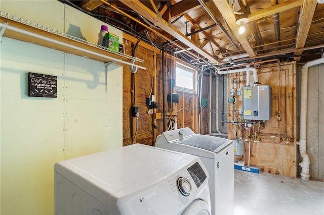 clothes washing area featuring washing machine and clothes dryer, laundry area, and water heater