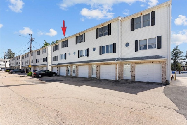 view of building exterior with a residential view and a garage