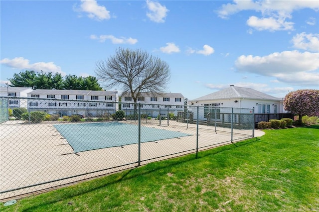 view of pool with fence and a lawn