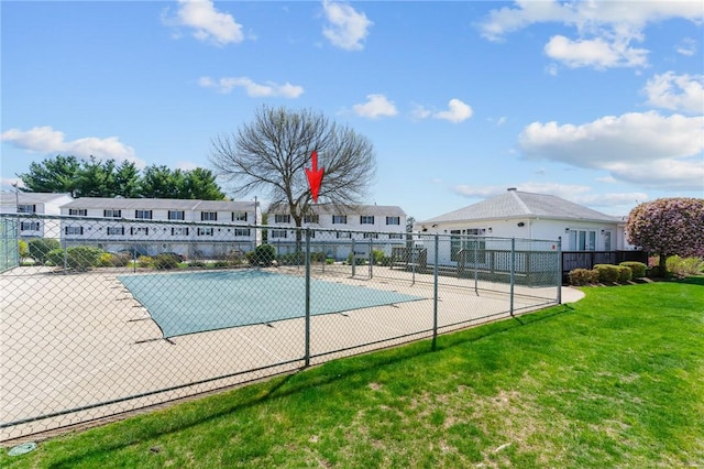 view of swimming pool featuring a lawn and fence