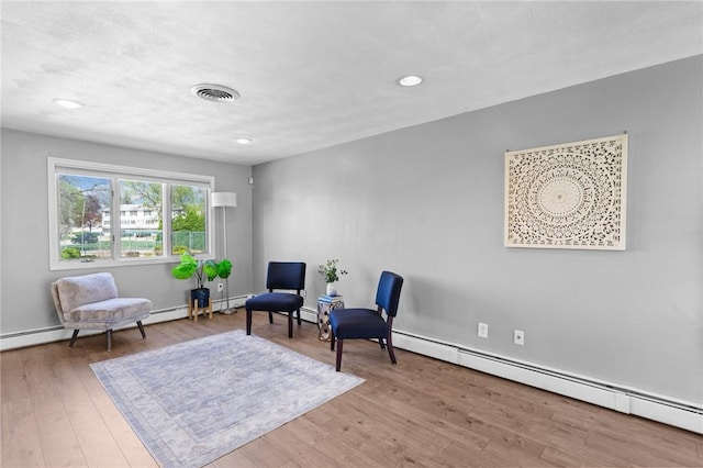 sitting room with visible vents, recessed lighting, wood finished floors, and baseboard heating