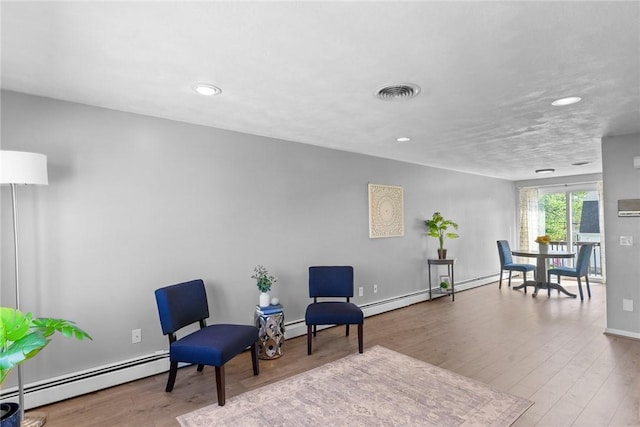 sitting room with visible vents, wood finished floors, baseboards, baseboard heating, and recessed lighting