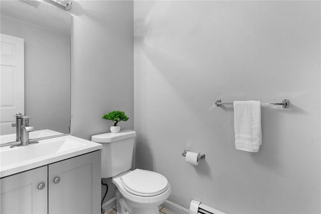 bathroom featuring vanity, baseboards, a baseboard heating unit, and toilet