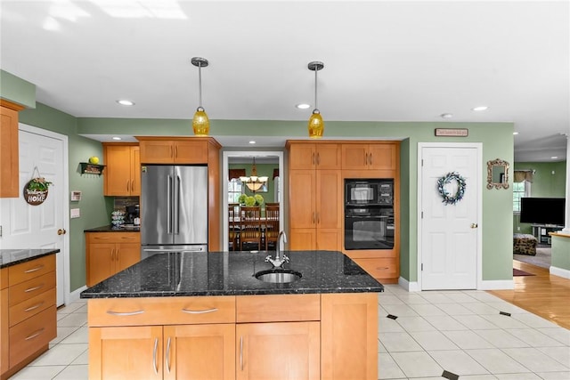 kitchen with a sink, hanging light fixtures, black appliances, and light tile patterned flooring