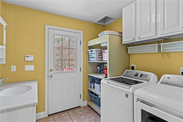 washroom featuring cabinet space, a sink, light tile patterned floors, baseboards, and washer and dryer