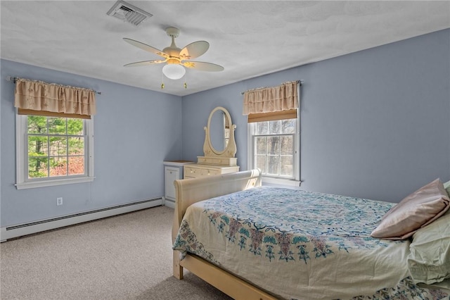 carpeted bedroom with a baseboard radiator, multiple windows, ceiling fan, and visible vents