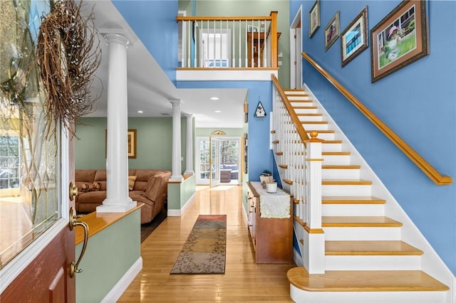 entryway featuring ornate columns, recessed lighting, wood finished floors, and stairway