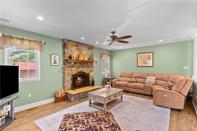 living area with baseboards, ceiling fan, visible vents, and wood finished floors