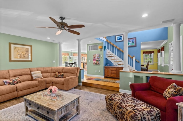 living area with a ceiling fan, decorative columns, plenty of natural light, and wood finished floors