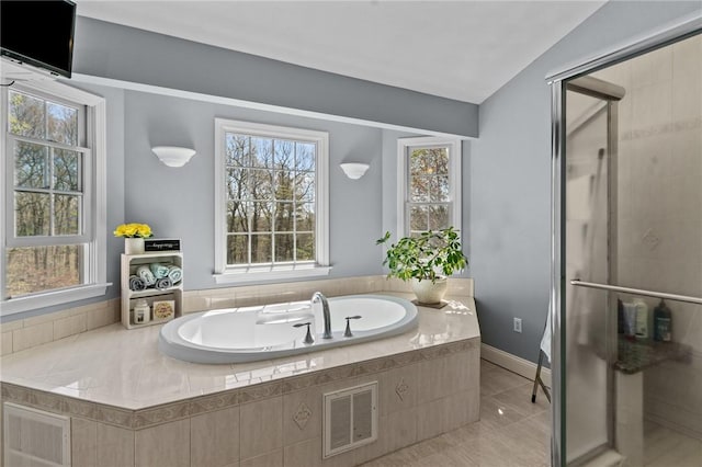 bathroom featuring visible vents, a wealth of natural light, a bath, and a stall shower