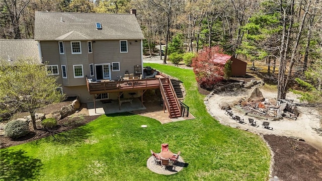 rear view of property featuring a deck, a yard, a patio area, and stairway