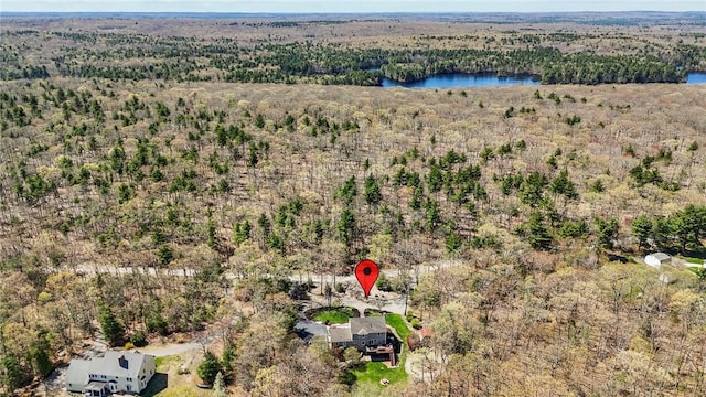 drone / aerial view featuring a water view and a wooded view