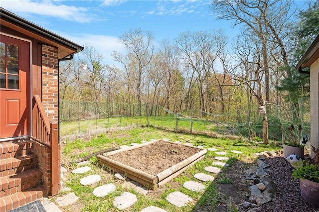 view of yard with fence and a vegetable garden