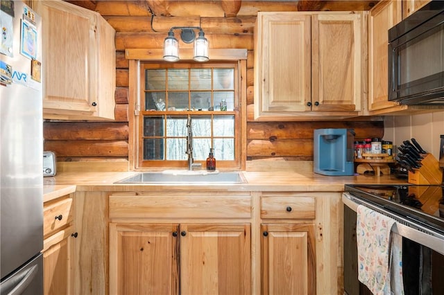 kitchen featuring a sink, appliances with stainless steel finishes, log walls, and light brown cabinets