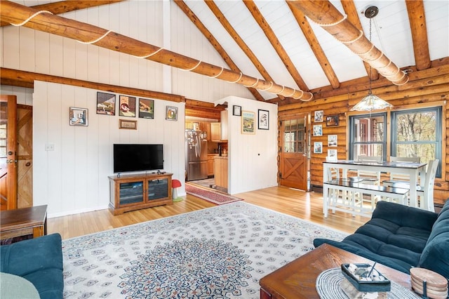 living area featuring beam ceiling, log walls, wood finished floors, and high vaulted ceiling