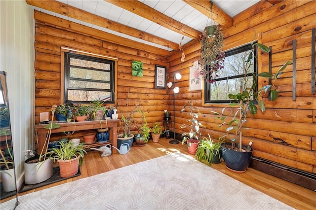 living area with beamed ceiling, wood finished floors, and a wealth of natural light