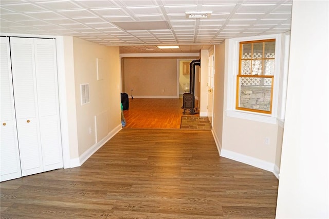 hallway featuring baseboards, wood finished floors, and visible vents