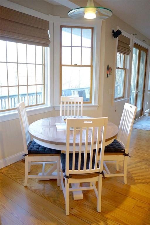 dining area with a ceiling fan, plenty of natural light, and wood finished floors