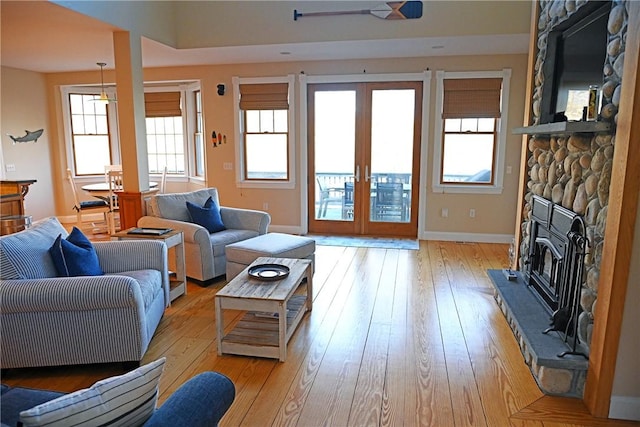 living room with baseboards, french doors, and light wood-style flooring