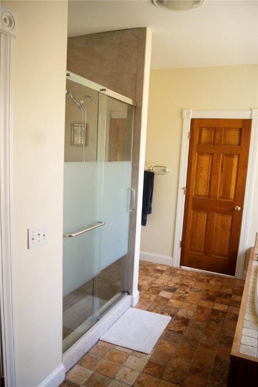 full bath with baseboards and a shower stall
