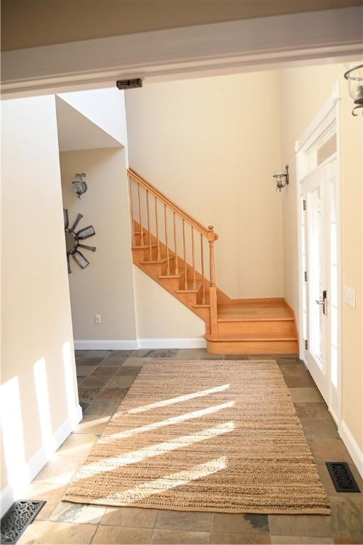entrance foyer with visible vents, stairs, and baseboards