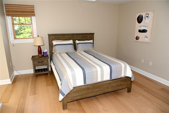 bedroom with baseboards and wood finished floors
