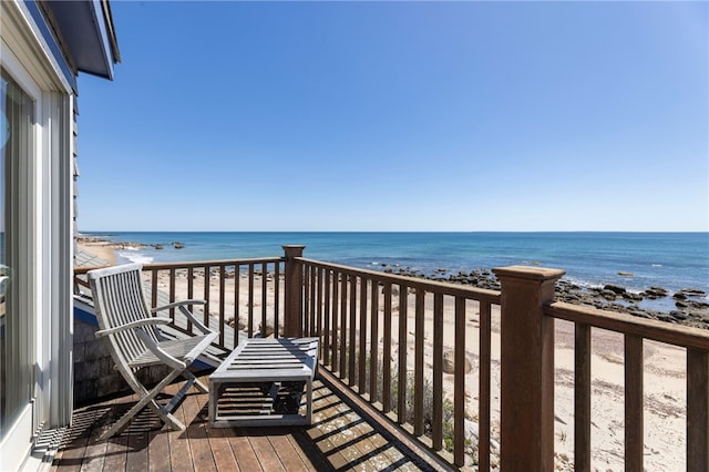 balcony featuring a beach view and a water view