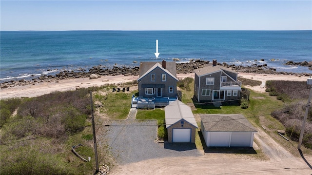 birds eye view of property with a water view and a beach view