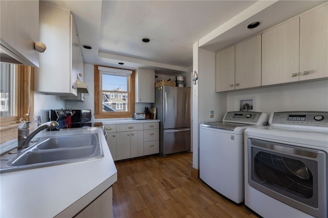 washroom featuring washer and dryer, laundry area, dark wood-style floors, and a sink