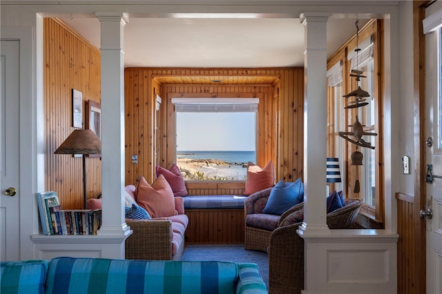 sitting room with wood walls and decorative columns