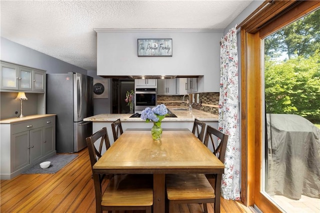 dining space with light wood-style flooring and a textured ceiling