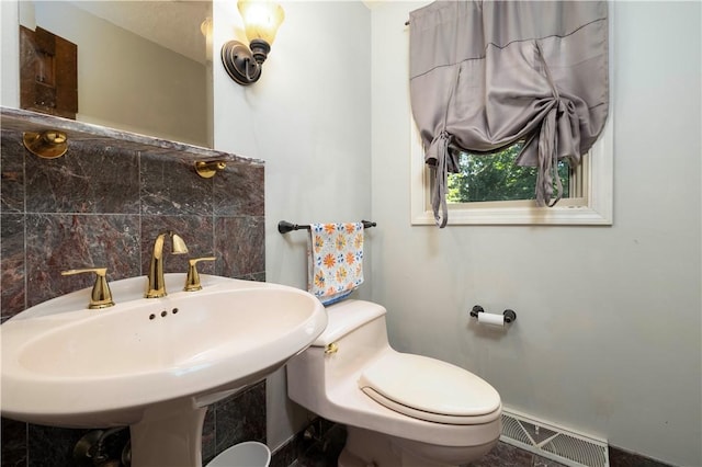 bathroom featuring a sink, toilet, and visible vents