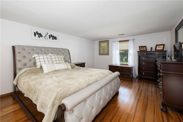 bedroom featuring visible vents and dark wood-style floors