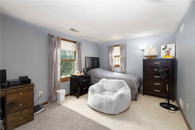 bedroom featuring a textured ceiling, visible vents, multiple windows, and carpet