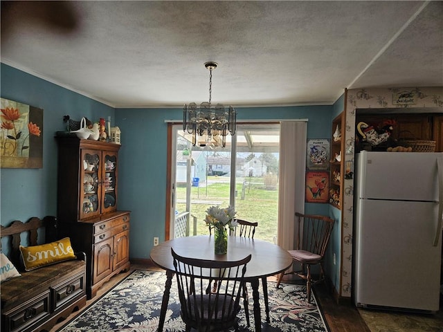dining space with light wood-style floors, a textured ceiling, crown molding, and a chandelier