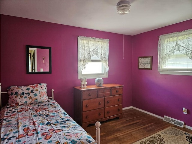bedroom featuring visible vents, baseboards, and dark wood-style floors