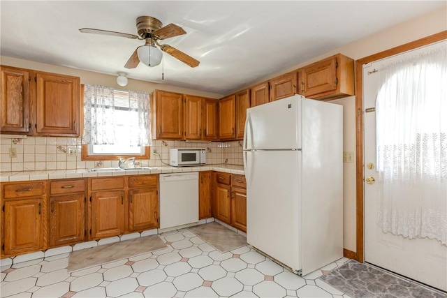 23 Oak Grove Blvd, North Providence, RI 02911 - kitchen with brown cabinetry, a ceiling fan, white appliances, tile counters, and a sink