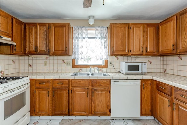 23 Oak Grove Blvd, North Providence, RI 02911 - kitchen featuring tasteful backsplash, brown cabinets, a sink, under cabinet range hood, and white appliances