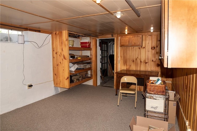 below grade area featuring carpet floors and wood walls