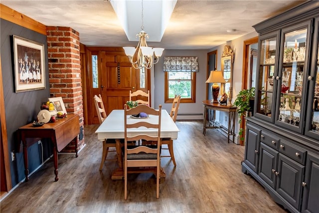 dining area featuring an inviting chandelier, wood finished floors, baseboards, wooden walls, and a baseboard radiator