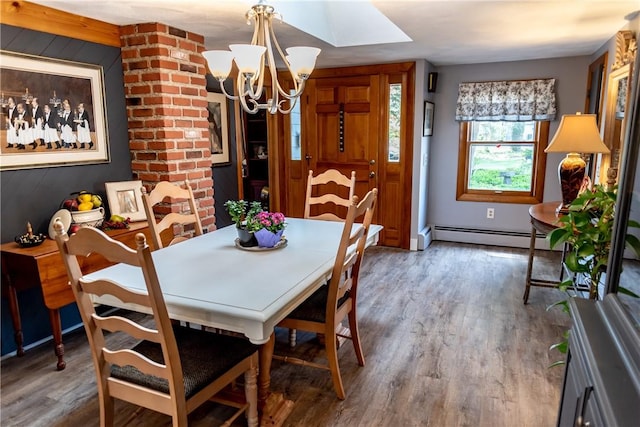 dining room with a skylight, a baseboard radiator, wood finished floors, and a chandelier