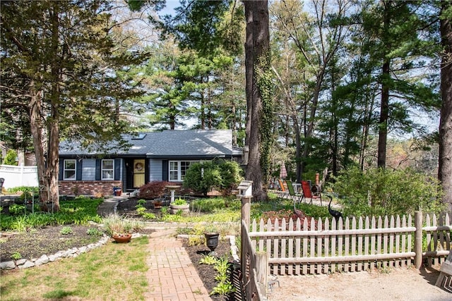 view of front of home with brick siding and fence