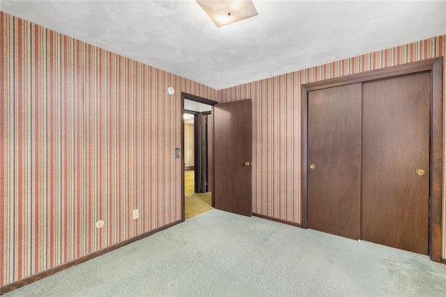 49 Magnolia Ln, Coventry, RI 02816 - unfurnished bedroom featuring a closet, carpet flooring, baseboards, and wallpapered walls