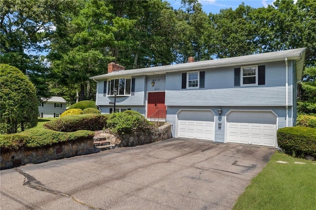 49 Magnolia Ln, Coventry, RI 02816 - raised ranch featuring an attached garage, a chimney, and aphalt driveway