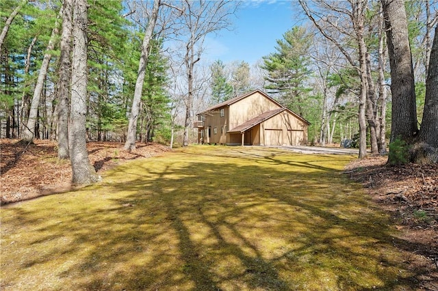 view of yard with a garage and driveway