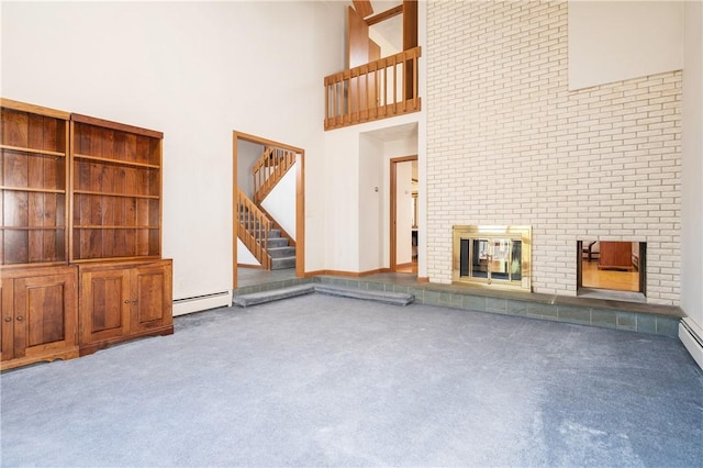 unfurnished living room featuring carpet floors, a high ceiling, a fireplace, and stairway