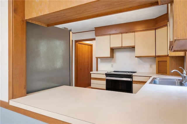 kitchen with a sink, light countertops, and electric range