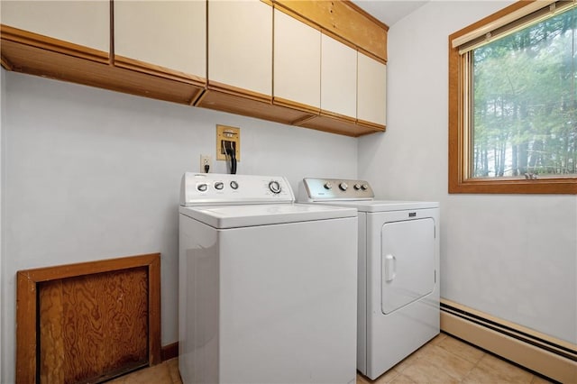 laundry room with cabinet space, light tile patterned flooring, washing machine and dryer, and baseboard heating