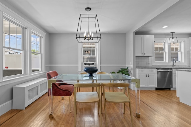 dining area with radiator, recessed lighting, light wood-style flooring, and a notable chandelier