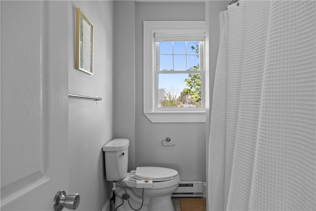 bathroom with baseboards, curtained shower, baseboard heating, and toilet